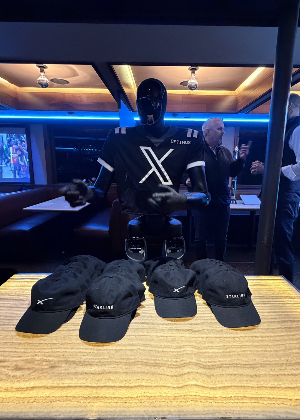 Inside X Football City Diner: Optimus in an X jersey, guests and Starlink caps