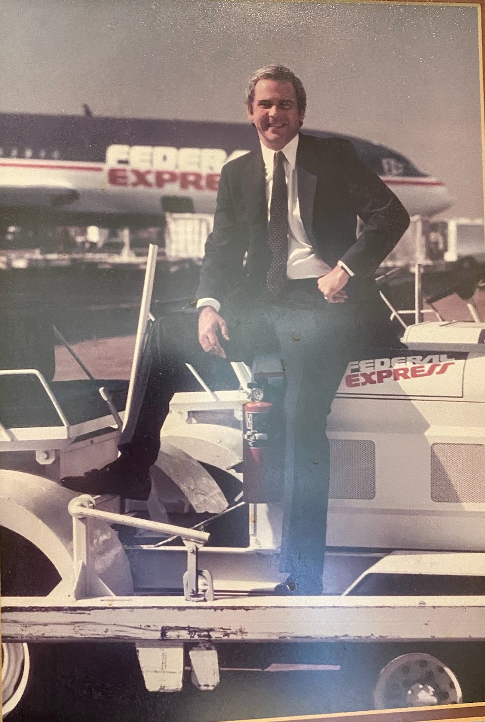 Archival photograph of Frederick W. Smith beside a Federal Express jet