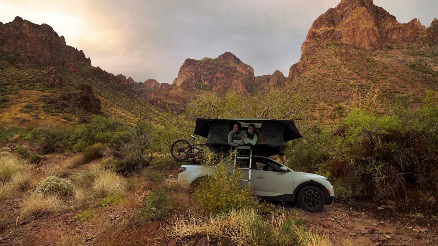 A vehicle with a rooftop tent in a red rock desert
