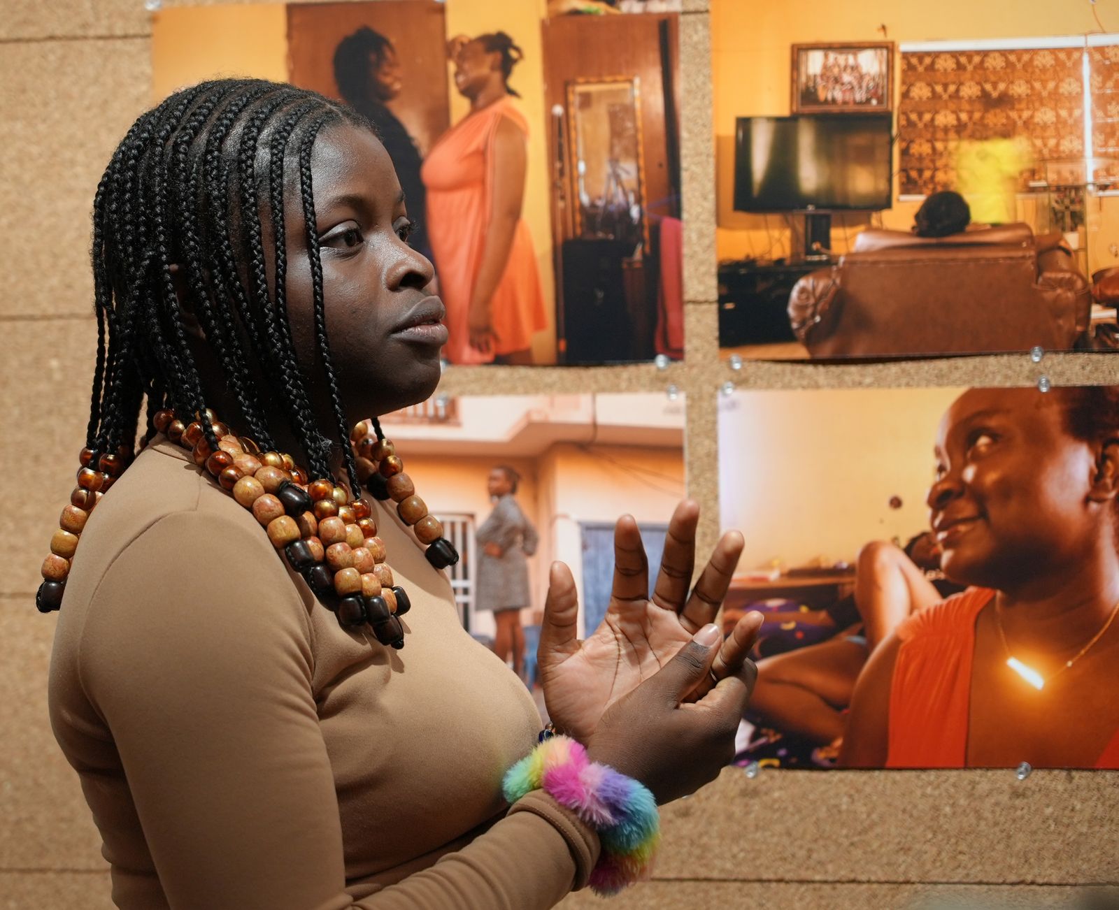 A guest speaks in front of a wall of pinned open call photographs of homes