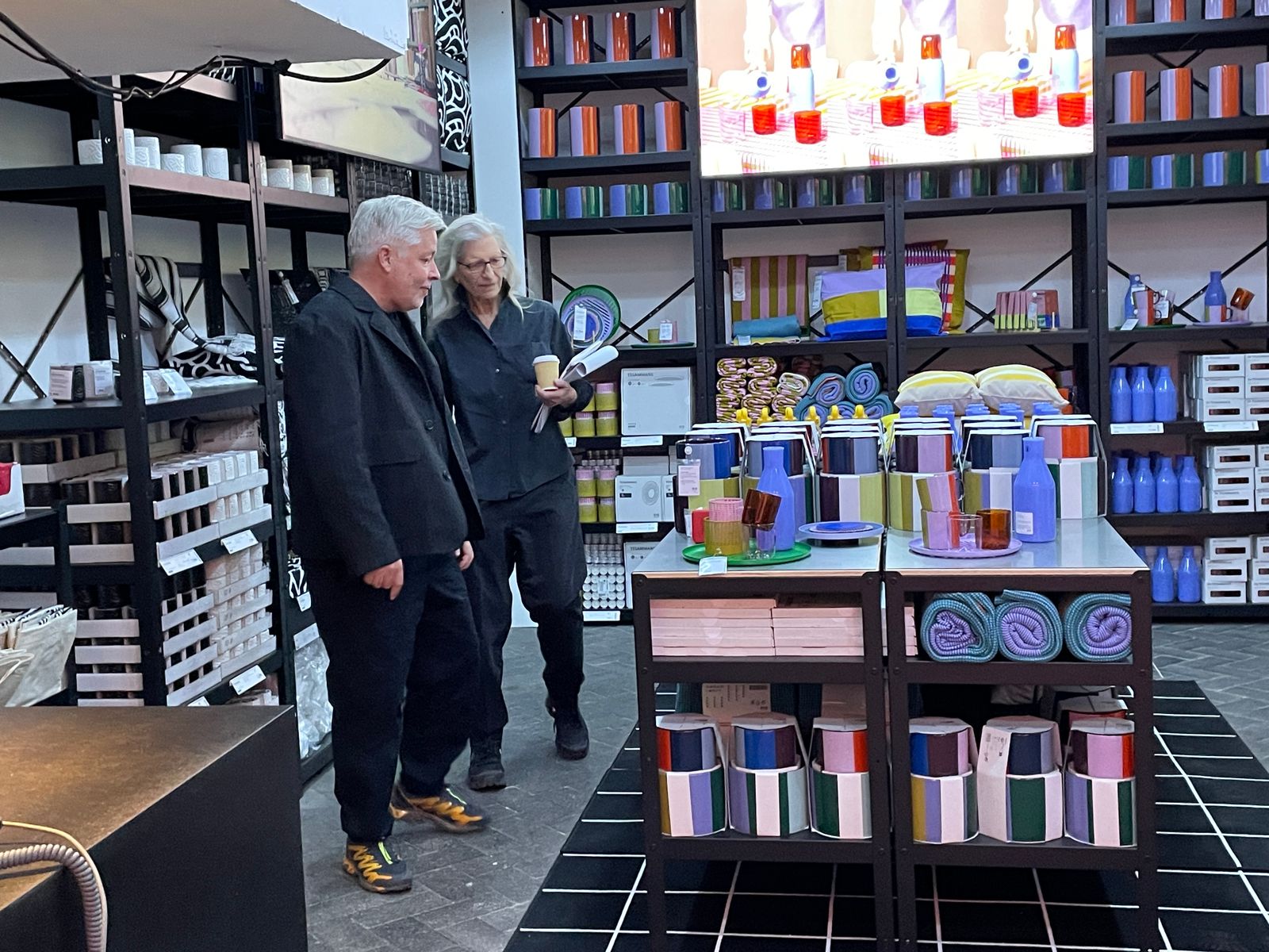 Annie Leibovitz and a guest tour a shelving display of colorful IKEA+ products