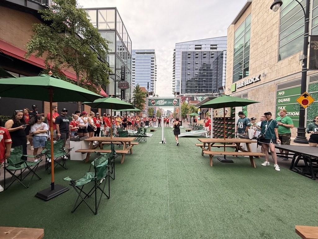 Picnic tables and co-branded umbrellas along the turf