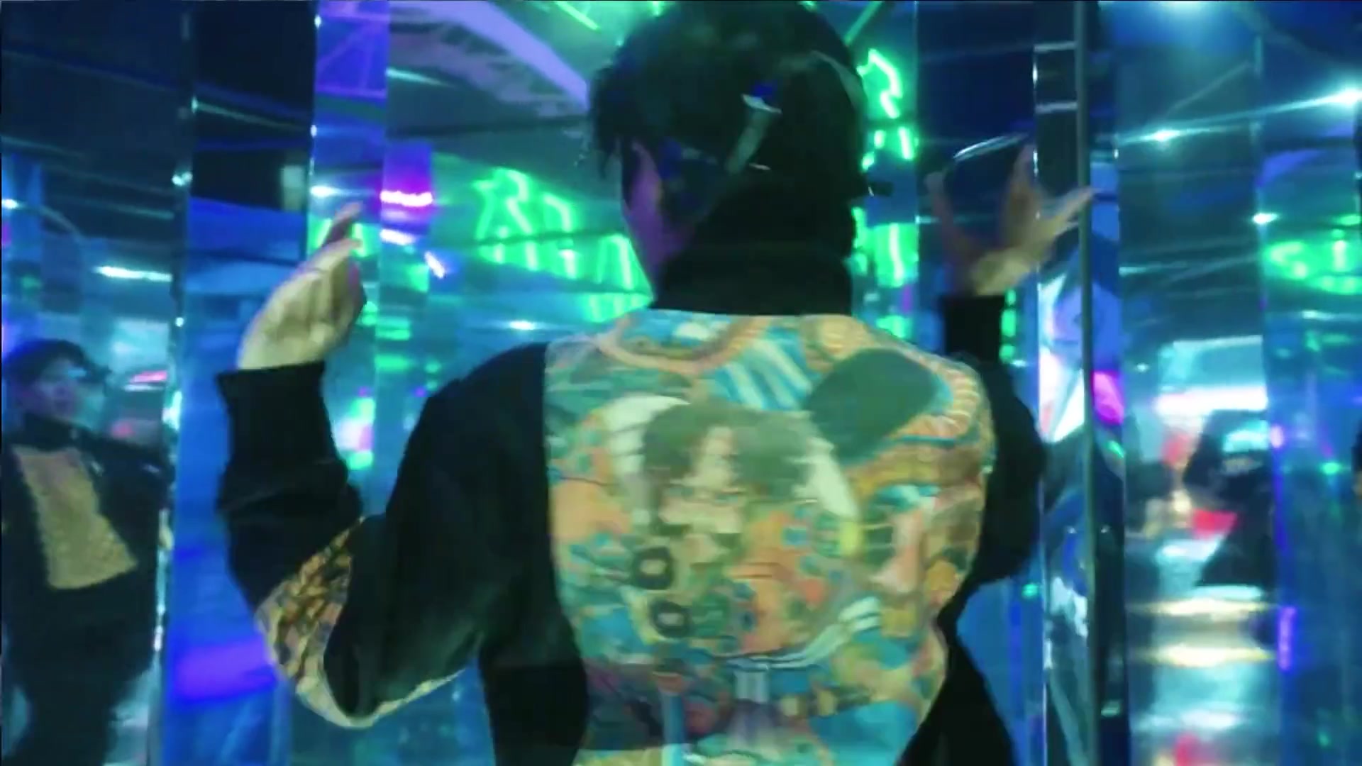 A guest moves through a mirrored, neon-lit room at Dynamic Land