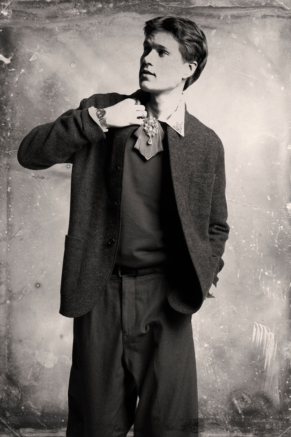 A creator in a tweed jacket with a jeweled collar brooch, finished as a tintype portrait